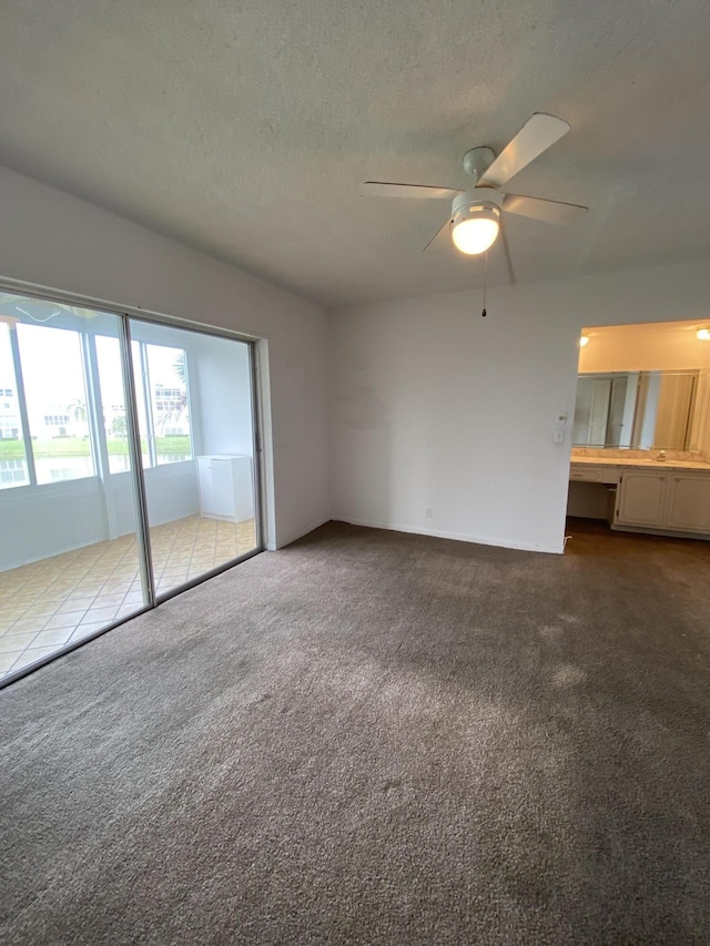 interior space with ceiling fan, built in desk, carpet floors, and a textured ceiling