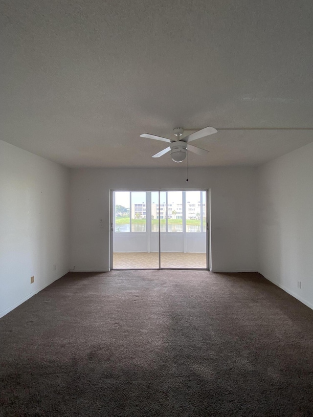 carpeted spare room with a textured ceiling and ceiling fan