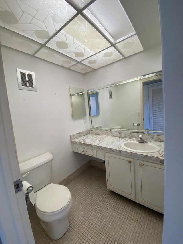 bathroom featuring vanity, tile patterned floors, and toilet