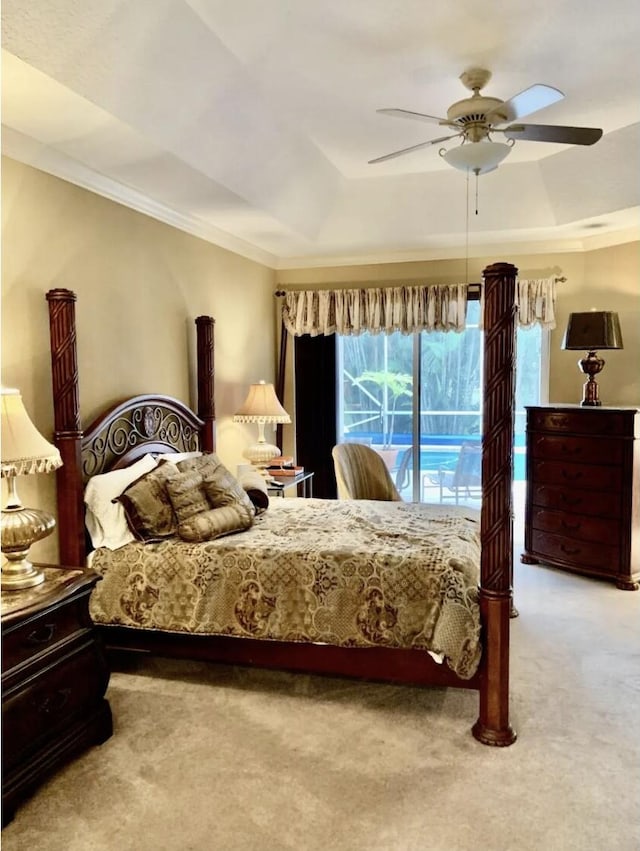 carpeted bedroom with a tray ceiling, ornamental molding, access to outside, and ceiling fan