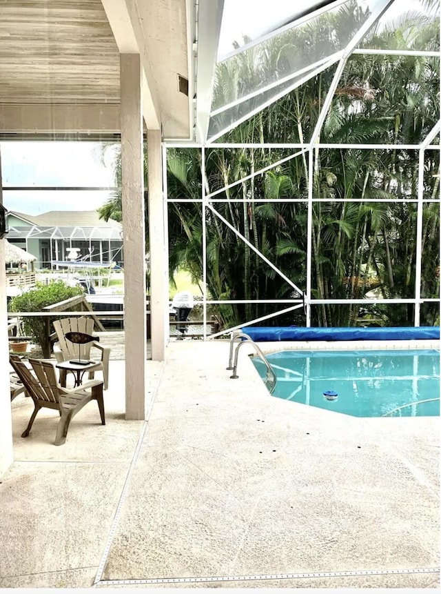 view of swimming pool featuring a lanai and a patio area