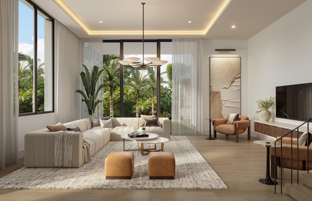 living room with floor to ceiling windows, a tray ceiling, a notable chandelier, and light wood-type flooring