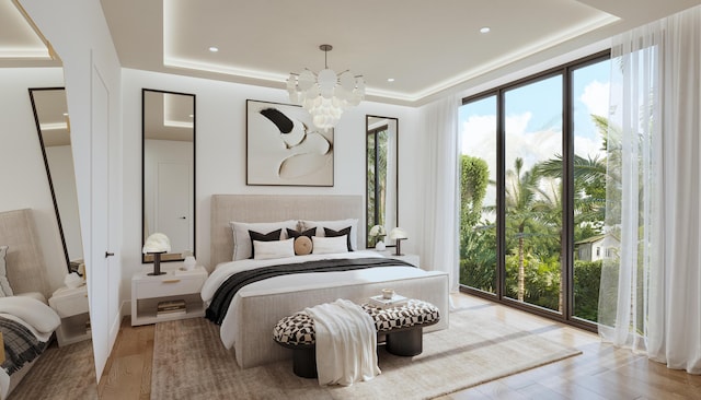 bedroom featuring light hardwood / wood-style floors, a tray ceiling, and a notable chandelier