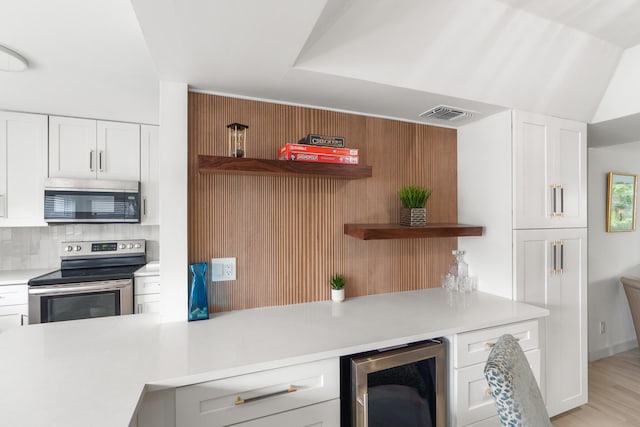 kitchen with light wood-type flooring, white cabinets, electric range, beverage cooler, and tasteful backsplash