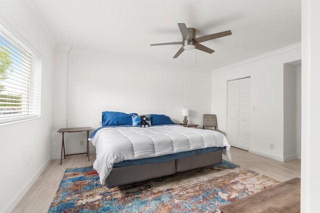 bedroom with a closet, ceiling fan, light hardwood / wood-style floors, and ornamental molding