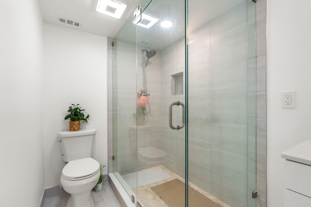 bathroom featuring a shower with shower door, tile flooring, vanity, and toilet