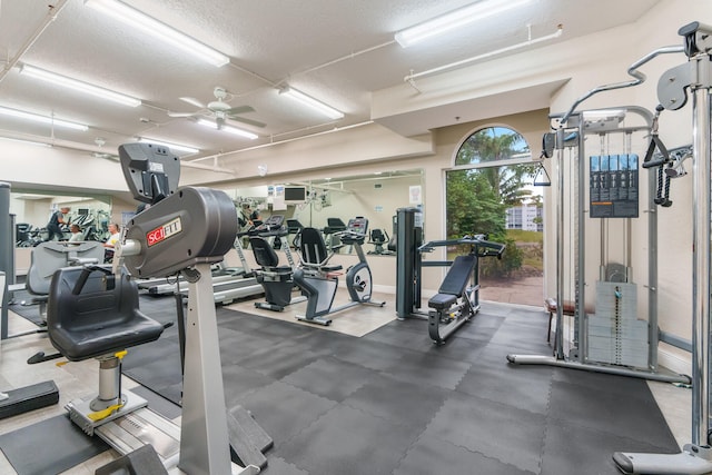 gym featuring ceiling fan and a textured ceiling