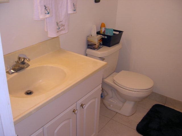 bathroom featuring tile flooring, vanity, and toilet