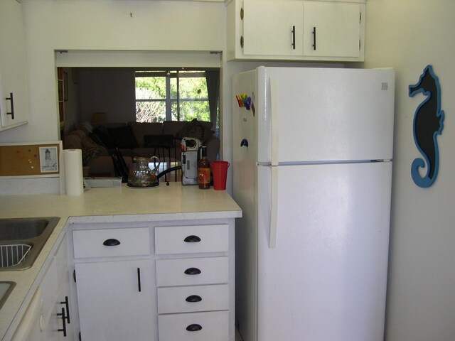 1172 Commodore Ct Unit 204, Fort Pierce, FL 34949 - kitchen with freestanding refrigerator, light countertops, and white cabinets