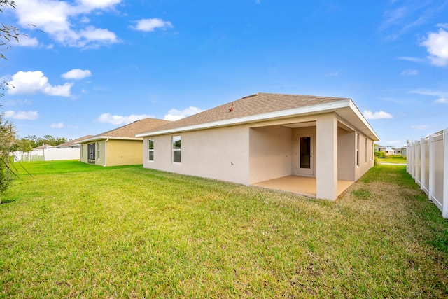 rear view of house featuring a lawn and a patio