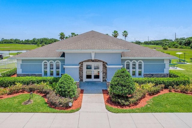 ranch-style home with french doors and a front yard