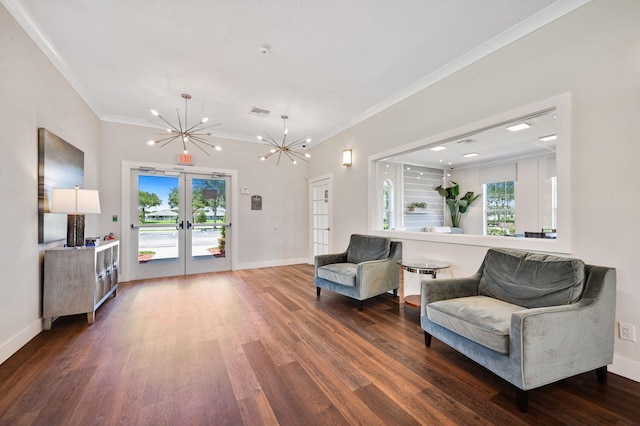 living area featuring a chandelier, french doors, dark hardwood / wood-style flooring, and crown molding