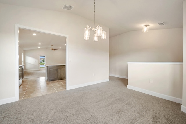 spare room featuring ceiling fan with notable chandelier, light carpet, and vaulted ceiling