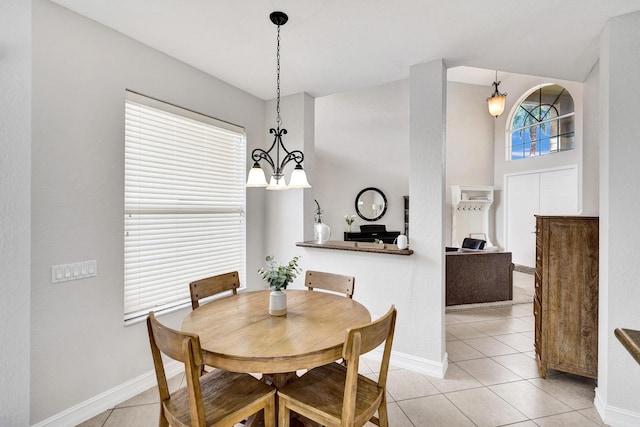 dining area with a chandelier, light tile patterned floors, and baseboards
