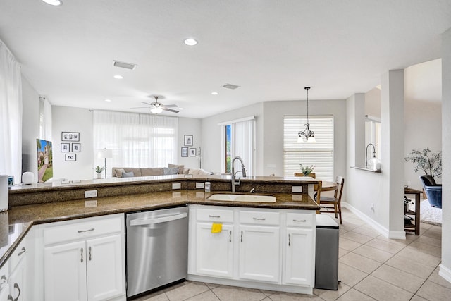 kitchen featuring stainless steel dishwasher, a sink, white cabinetry, light tile patterned floors, and recessed lighting