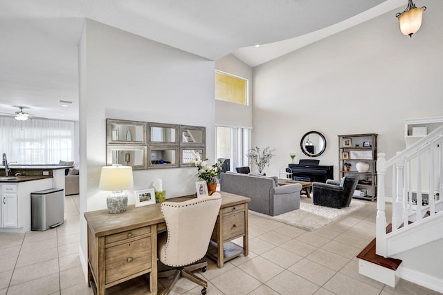 office with high vaulted ceiling, healthy amount of natural light, light tile patterned flooring, and ceiling fan