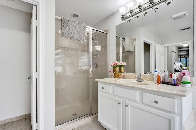 bathroom with tile patterned floors, a stall shower, and vanity
