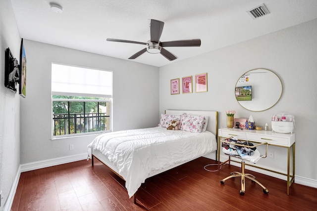 bedroom featuring baseboards, wood finished floors, and a ceiling fan