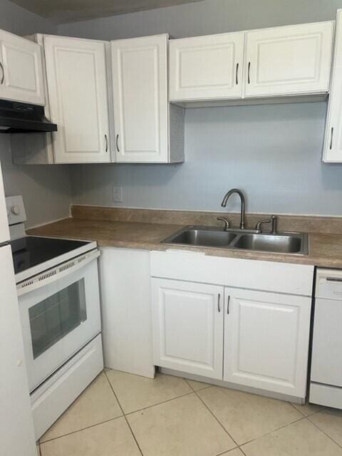 kitchen with sink, white cabinetry, light tile patterned flooring, and white appliances