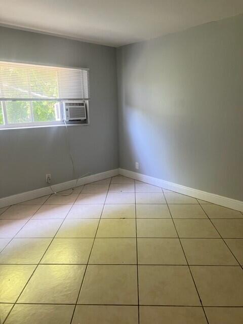 tiled spare room featuring cooling unit