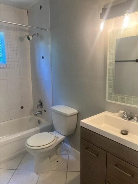 full bathroom featuring tile patterned floors, vanity, tiled shower / bath combo, and toilet