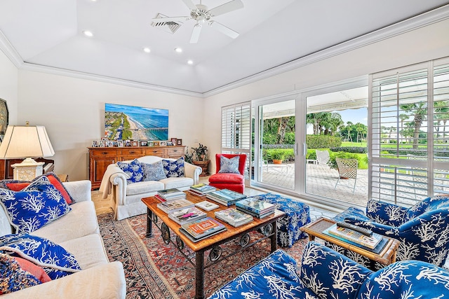 living room featuring a tray ceiling, ceiling fan, ornamental molding, and a healthy amount of sunlight