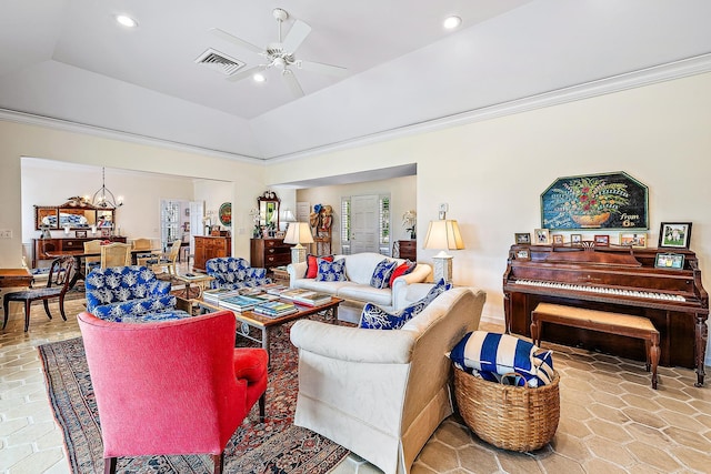 living room featuring lofted ceiling, ceiling fan with notable chandelier, and a raised ceiling