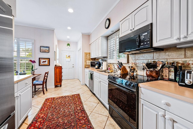 kitchen featuring black appliances, decorative backsplash, and white cabinetry