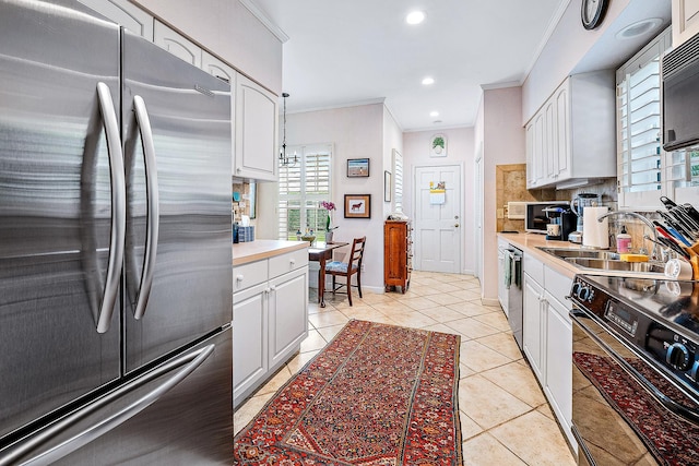 kitchen featuring appliances with stainless steel finishes, white cabinets, and decorative backsplash