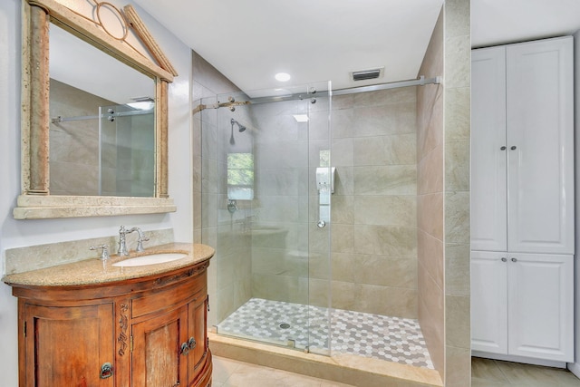 bathroom with tile patterned floors, an enclosed shower, and vanity