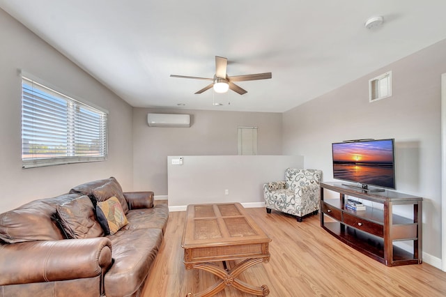 living room featuring an AC wall unit, ceiling fan, and light wood-type flooring