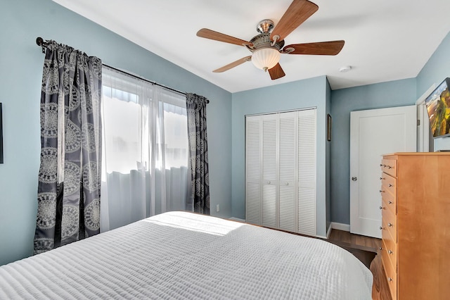 bedroom with ceiling fan, dark wood-type flooring, and a closet