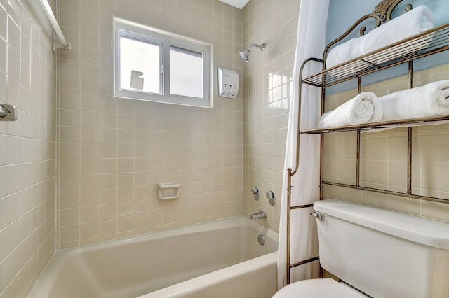 bathroom with tiled shower / bath combo and toilet