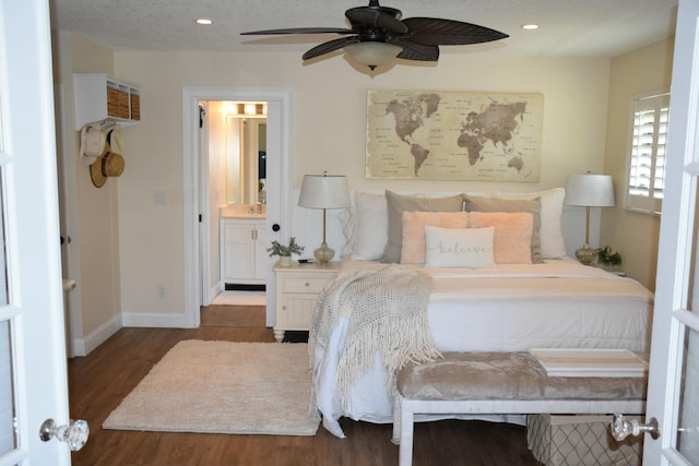 bedroom with dark wood-type flooring, ceiling fan, and ensuite bathroom