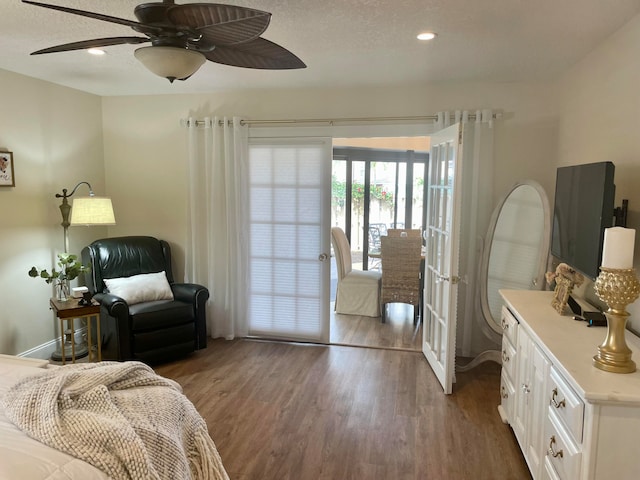 bedroom with dark hardwood / wood-style floors, ceiling fan, and french doors