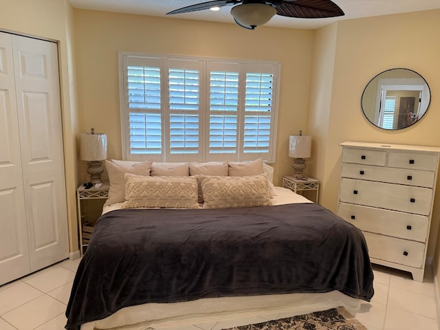 bedroom with light tile patterned floors, a closet, and ceiling fan