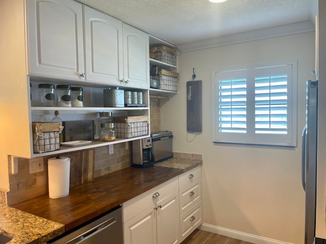 kitchen featuring ornamental molding, dark hardwood / wood-style flooring, white cabinets, stainless steel appliances, and backsplash