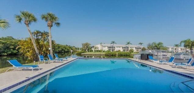 view of swimming pool featuring a water view and a patio