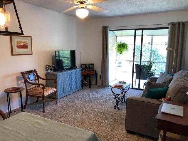 living room with ceiling fan and carpet flooring