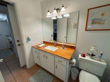 bathroom with a chandelier, vanity, toilet, and tile patterned floors