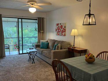 carpeted living room with a ceiling fan