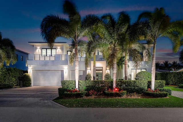 view of front of property featuring a garage and a balcony