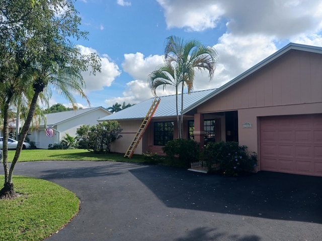 single story home featuring a front yard and a garage