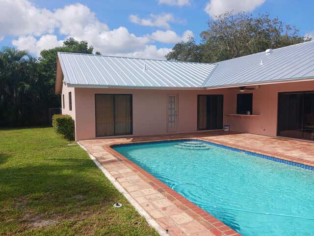 view of swimming pool featuring a lawn and a patio