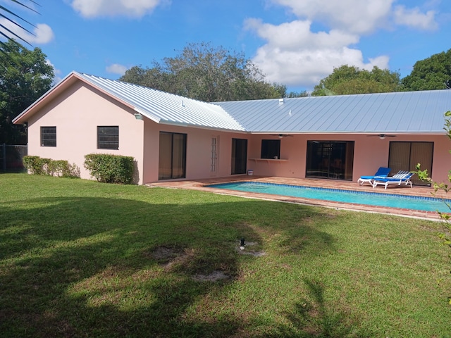 back of property with a lawn and a patio