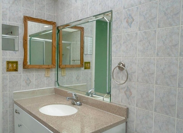 bathroom featuring vanity and tile walls