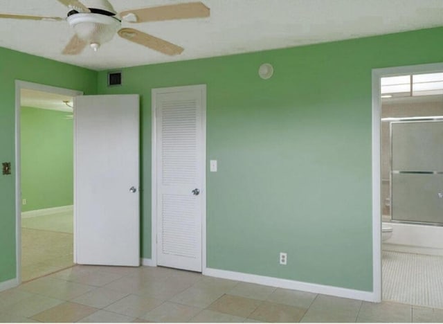 unfurnished bedroom featuring a closet, ceiling fan, and ensuite bathroom