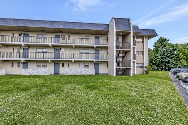 view of building exterior with stairway and uncovered parking