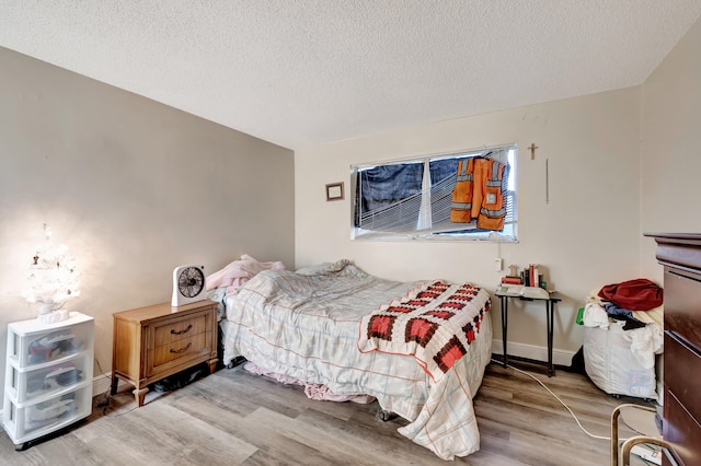 bedroom with hardwood / wood-style flooring and a textured ceiling