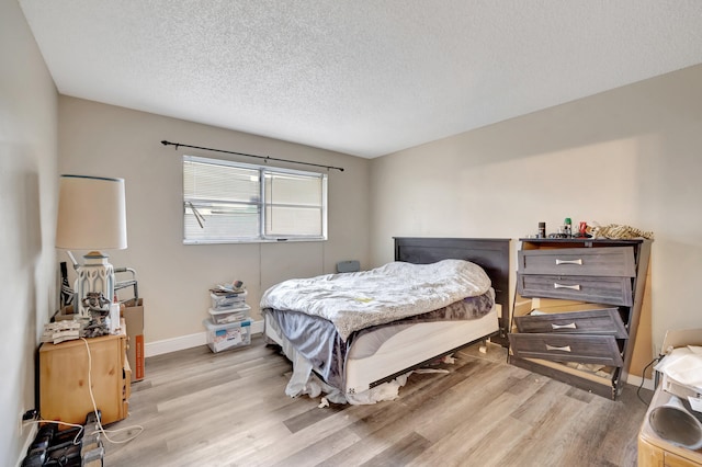 bedroom with light hardwood / wood-style flooring and a textured ceiling